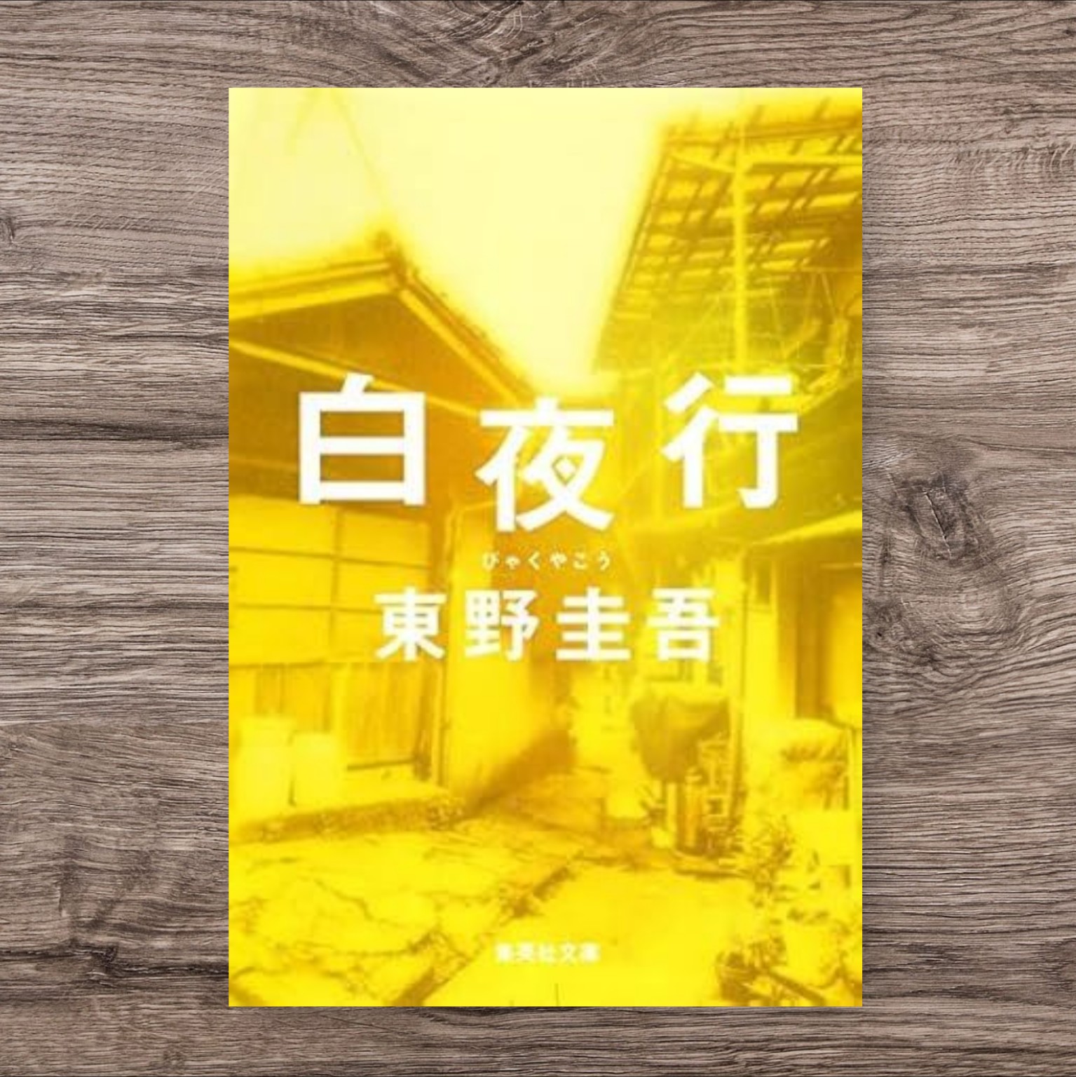 東野圭吾『白夜行』の文庫版カバー。レトロな路地裏の写真に黄色い光が差し込み、昭和の空気感と物語の陰影を印象づけるアイキャッチ画像。