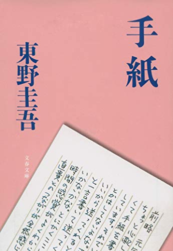 東野圭吾『手紙』の書影。ピンク色の背景に青文字でタイトルと著者名が書かれ、下部に手紙文面の一部が斜めに写っている。加害者家族の苦悩と向き合う小説の印象的な表紙。