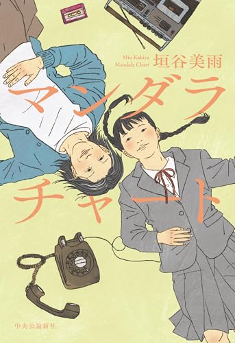 垣谷美雨『マンダラチャート』の表紙イラスト。昭和風の黒電話やカセットテープが描かれた背景に、制服姿の少女と中年女性が横たわる。時を超えて交差する2人の視線が、ジェンダー問題と人生の再選択を象徴するビジュアル。